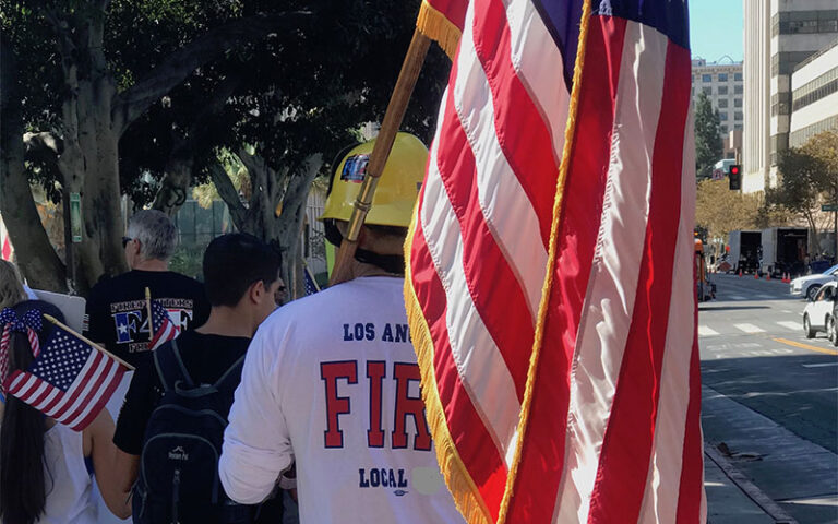 2 men carrying American flags walking