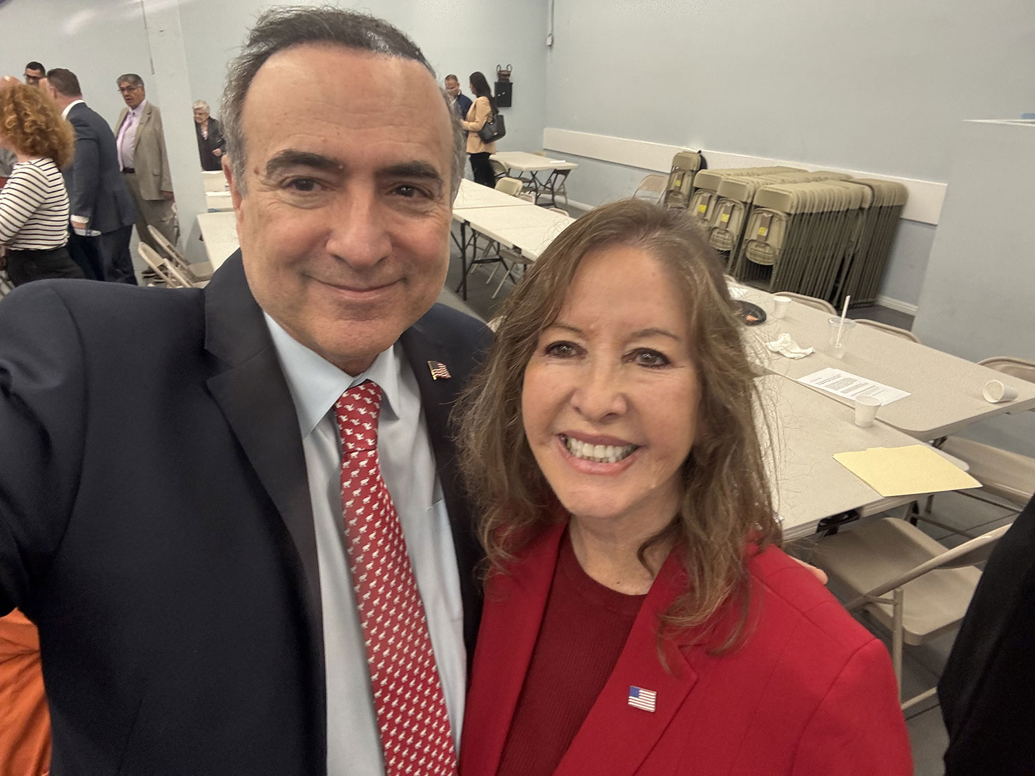 man smiling with a woman in red coat smiling