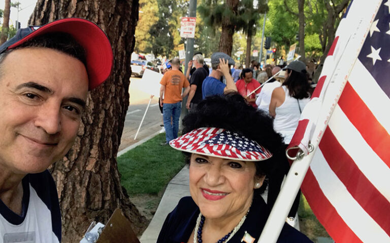 a man and a woman smiling with American flag